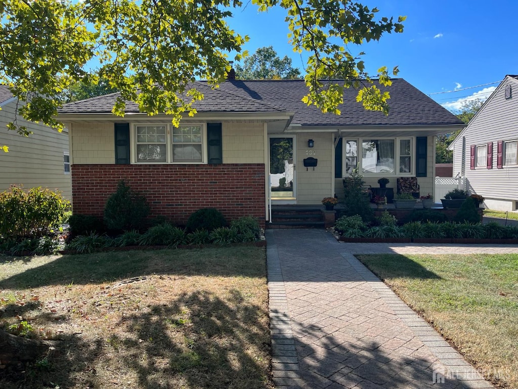 131 Hazelwood Ave, Metuchen, NJ 08840 - bungalow featuring brick siding, a front yard, and roof with shingles