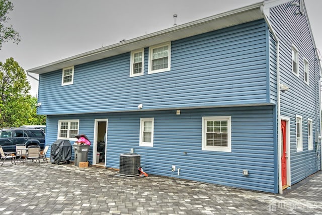 back of house with central air condition unit and a patio area