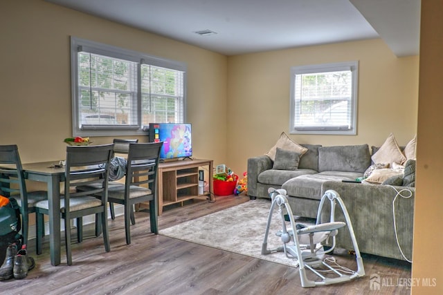 living area with healthy amount of natural light and wood finished floors