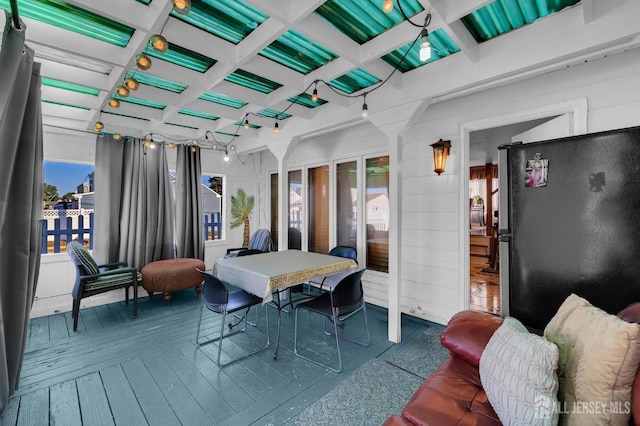 sunroom featuring beam ceiling, a wealth of natural light, and coffered ceiling