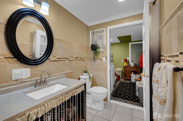 bathroom featuring tile patterned flooring, crown molding, toilet, vanity, and tile walls