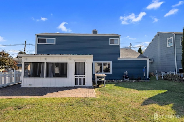 rear view of property featuring a patio area and a lawn