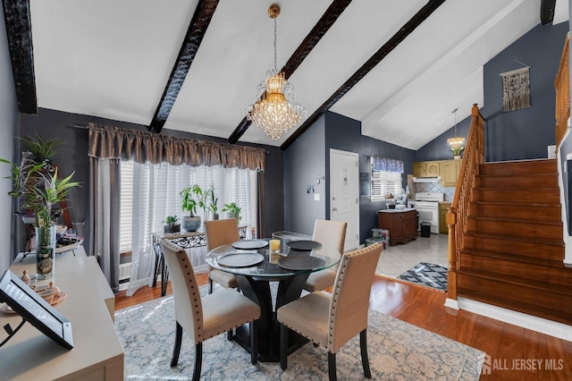 dining area with a healthy amount of sunlight, vaulted ceiling with beams, light hardwood / wood-style flooring, and a notable chandelier