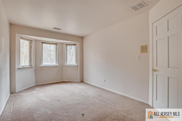 spare room featuring carpet flooring and baseboards