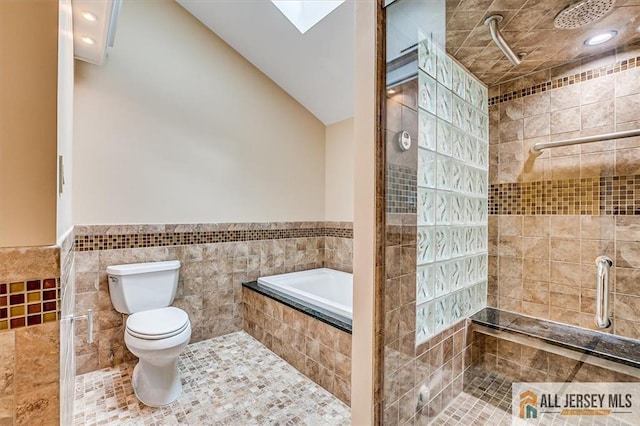full bath featuring toilet, tiled shower, tile walls, wainscoting, and a relaxing tiled tub
