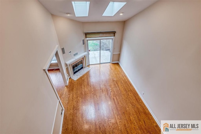 144 Coppertree Ct Unit 144, Edison, NJ 08820 - unfurnished living room with a skylight, a glass covered fireplace, and wood finished floors