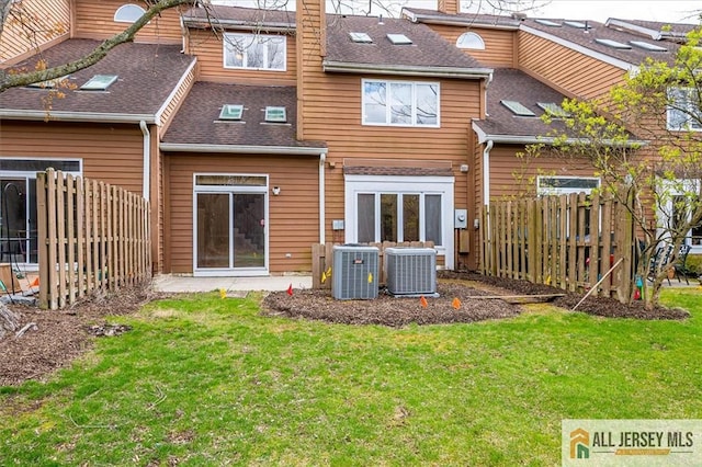 rear view of property with cooling unit and a shingled roof