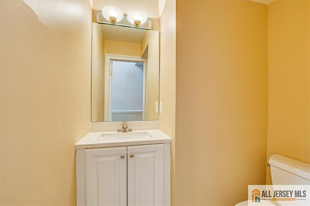 half bath featuring toilet and vanity