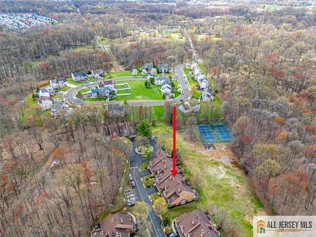 aerial view of property's location featuring a forest