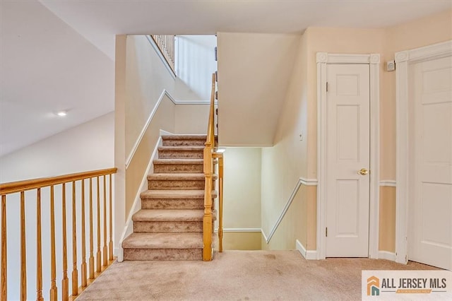 staircase featuring carpet floors and baseboards