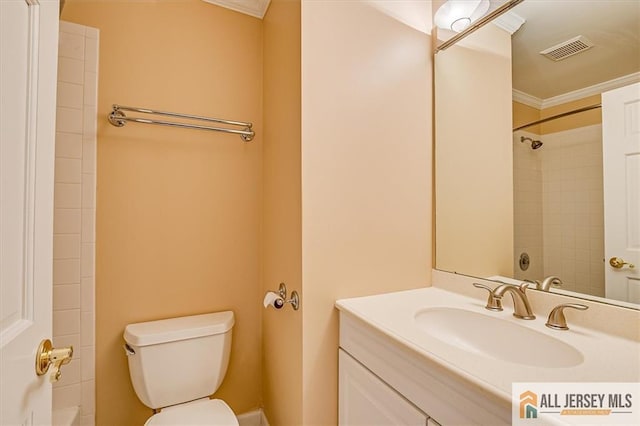 bathroom with toilet, vanity, and ornamental molding