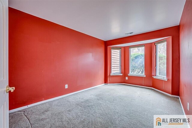 carpeted empty room with baseboards
