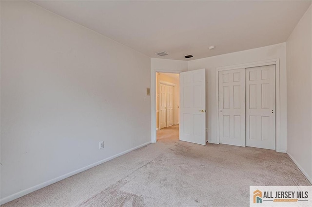 unfurnished bedroom with carpet flooring, baseboards, and a closet
