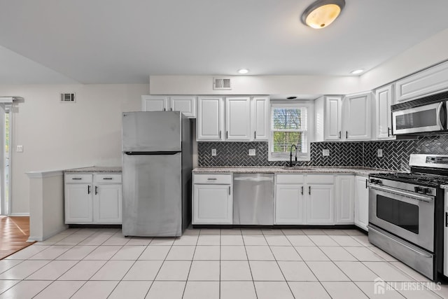 26 Jaime Ct, Old Bridge, NJ 08857 - kitchen featuring appliances with stainless steel finishes, tasteful backsplash, white cabinetry, and light tile patterned floors