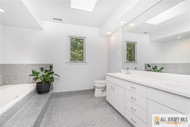 5 Leighton Dr, East Brunswick, NJ 08816 - bathroom featuring a skylight, double vanity, a garden tub, speckled floor, and recessed lighting