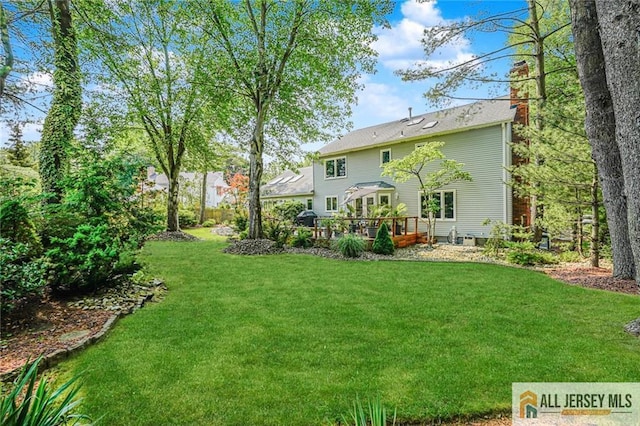 5 Leighton Dr, East Brunswick, NJ 08816 - back of property with a chimney, a lawn, and a deck