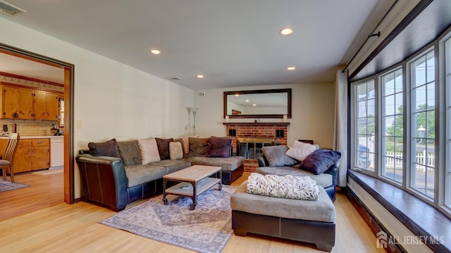 230 Raritan St, South Amboy, NJ 08879 - living area with light wood-style floors, recessed lighting, a baseboard radiator, and a fireplace