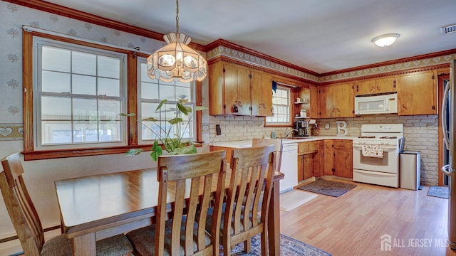 230 Raritan St, South Amboy, NJ 08879 - kitchen featuring white appliances, a chandelier, light countertops, brown cabinets, and light wood-style floors