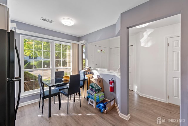 dining space with baseboards, wood finished floors, and visible vents