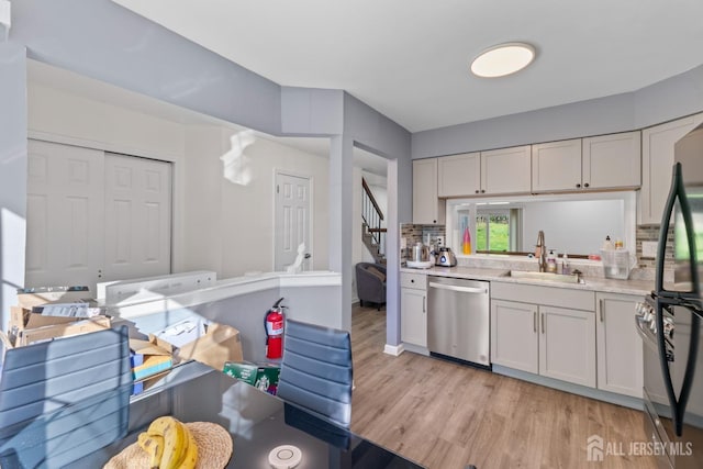 kitchen with freestanding refrigerator, light countertops, a sink, light wood-style flooring, and dishwasher