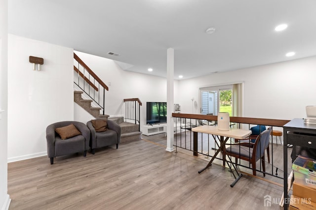 sitting room with stairs, recessed lighting, visible vents, and light wood-type flooring