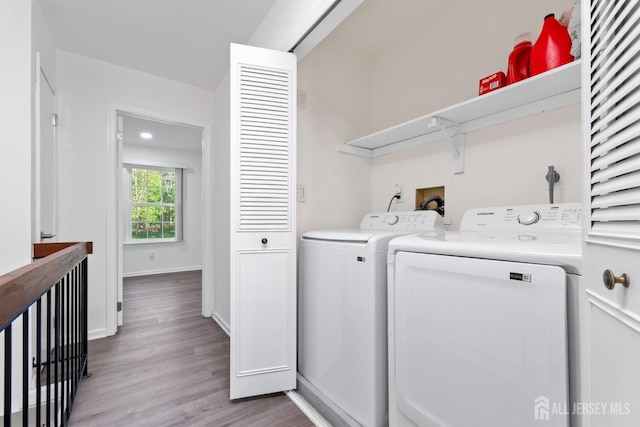 clothes washing area with baseboards, laundry area, light wood finished floors, and washer and dryer