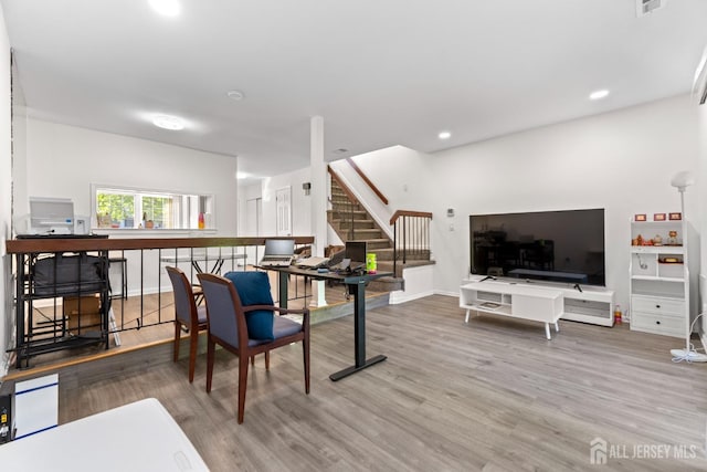living room featuring baseboards, recessed lighting, wood finished floors, and stairway