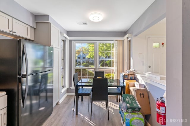 dining space with baseboards, visible vents, and wood finished floors