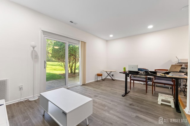 office area featuring baseboards, visible vents, and wood finished floors