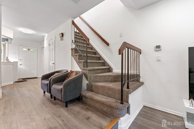 stairway with baseboards and wood finished floors