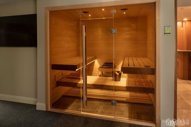 view of sauna featuring wood walls and carpet