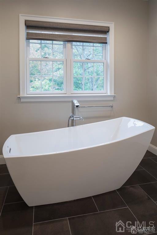 bathroom with a bathing tub and tile patterned flooring