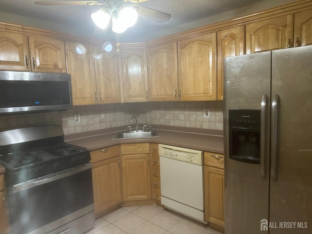 kitchen featuring decorative backsplash, sink, stainless steel appliances, and light tile patterned flooring