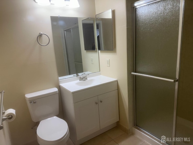 bathroom featuring an enclosed shower, vanity, tile patterned flooring, and toilet