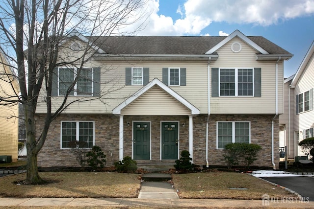 view of front of property with stone siding and a shingled roof