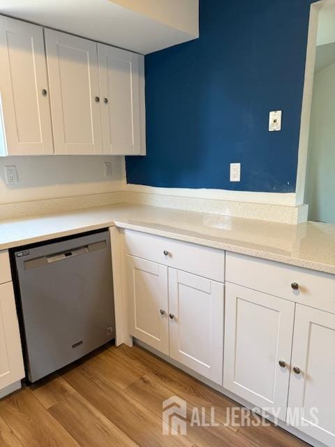 kitchen featuring light countertops, white cabinets, dishwasher, and light wood-style flooring