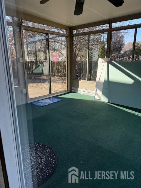 unfurnished sunroom with ceiling fan