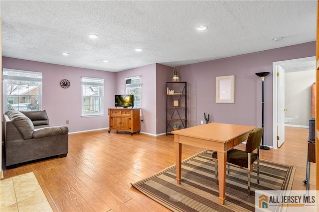 office space featuring a textured ceiling and light hardwood / wood-style floors