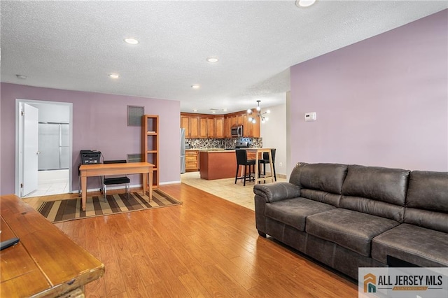 living room featuring a textured ceiling and light hardwood / wood-style floors