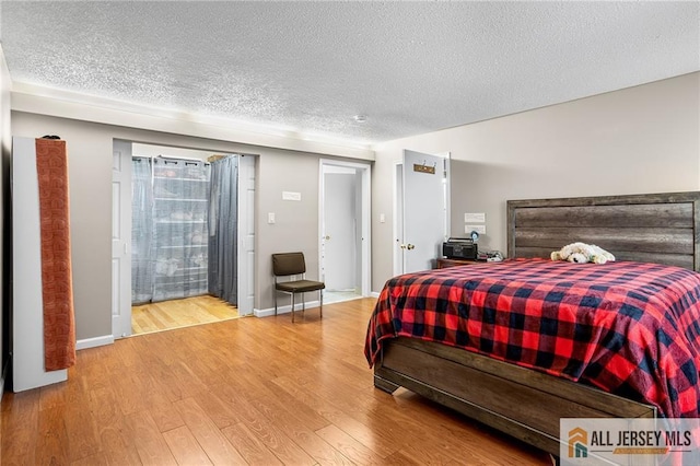 bedroom with wood-type flooring and a textured ceiling