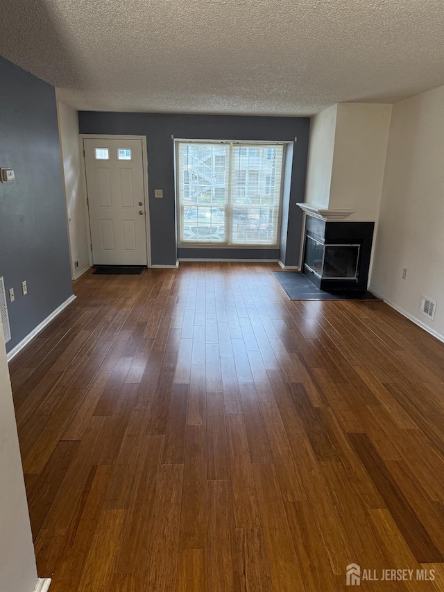 425 Northam Dr, North Brunswick, NJ 08902 - unfurnished living room with dark wood-style floors, a textured ceiling, and a fireplace