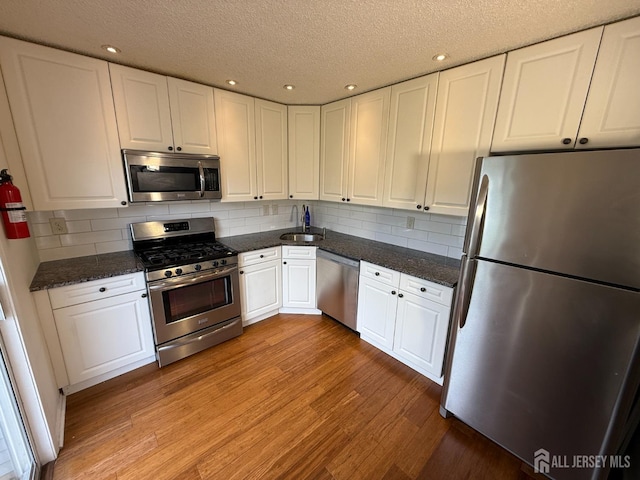 425 Northam Dr, North Brunswick, NJ 08902 - kitchen featuring stainless steel appliances, light wood finished floors, white cabinets, a textured ceiling, and recessed lighting