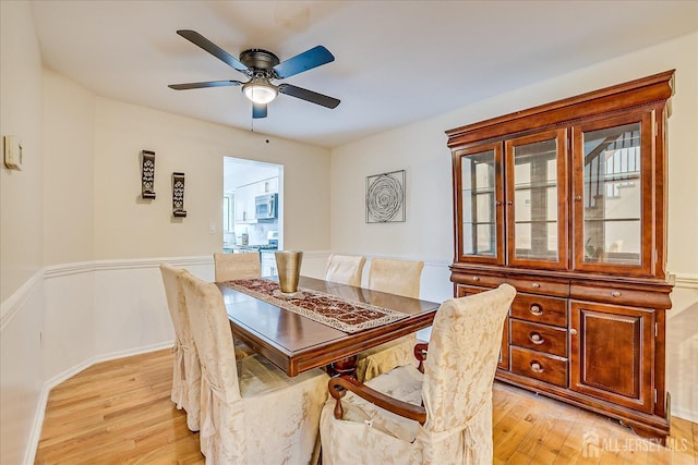 dining space with ceiling fan and light wood-type flooring