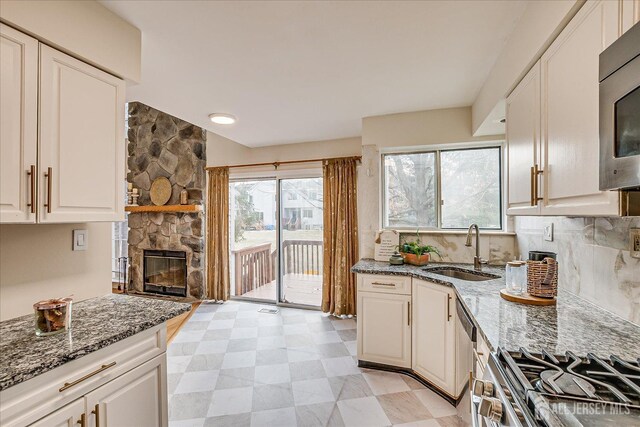 kitchen with stone counters, white cabinetry, and sink