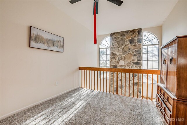 hall featuring carpet and lofted ceiling