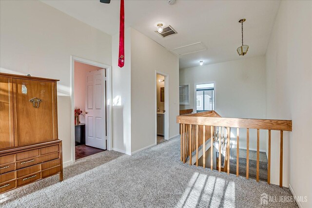 hall featuring lofted ceiling and dark colored carpet