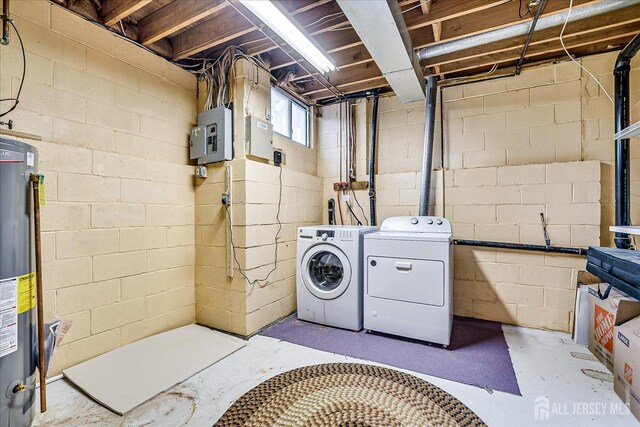 clothes washing area featuring electric panel, washer and dryer, and gas water heater