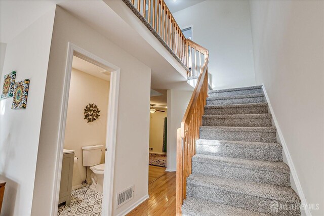 stairway with ceiling fan and hardwood / wood-style floors