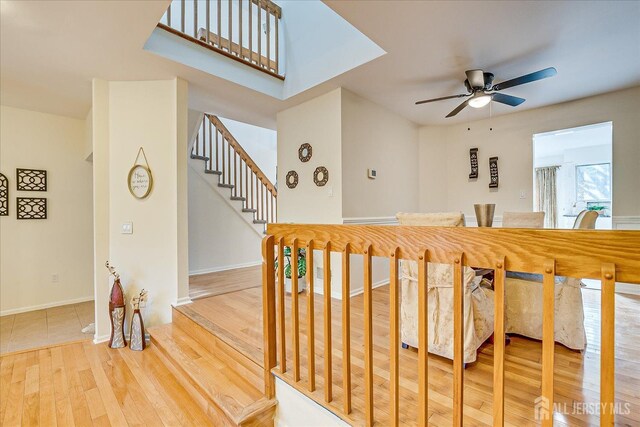 stairway featuring ceiling fan and hardwood / wood-style flooring