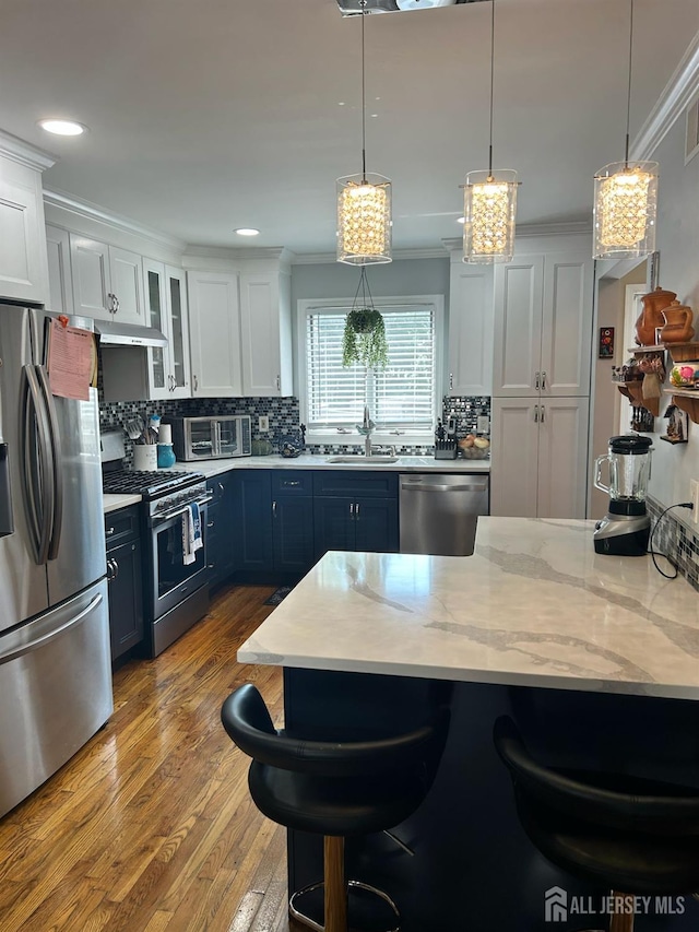 741 Bound Brook Rd, Dunellen, NJ 08812 - kitchen with stainless steel appliances, a breakfast bar, blue cabinets, white cabinets, and tasteful backsplash